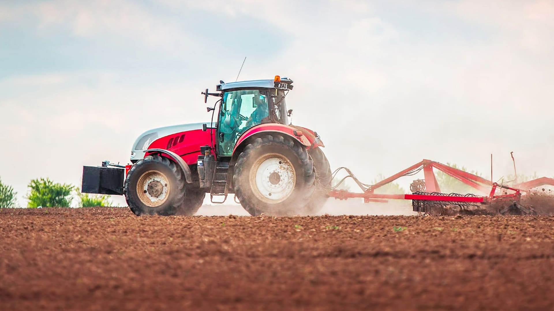 red tractor ploughing field