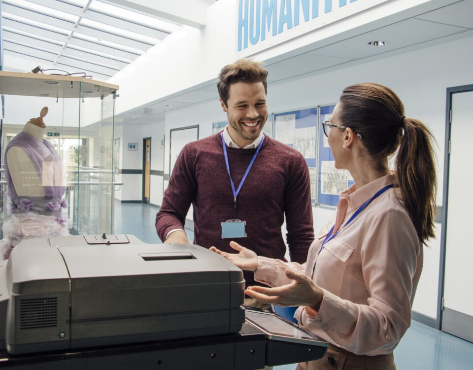 man and woman using printer photocopier in university