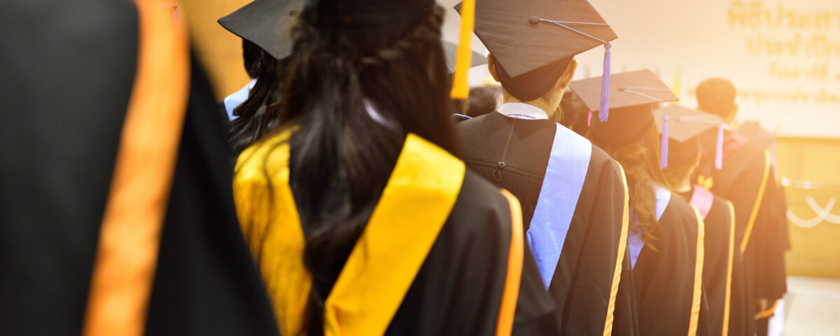 university graduates on graduation caps gowns gold sashes