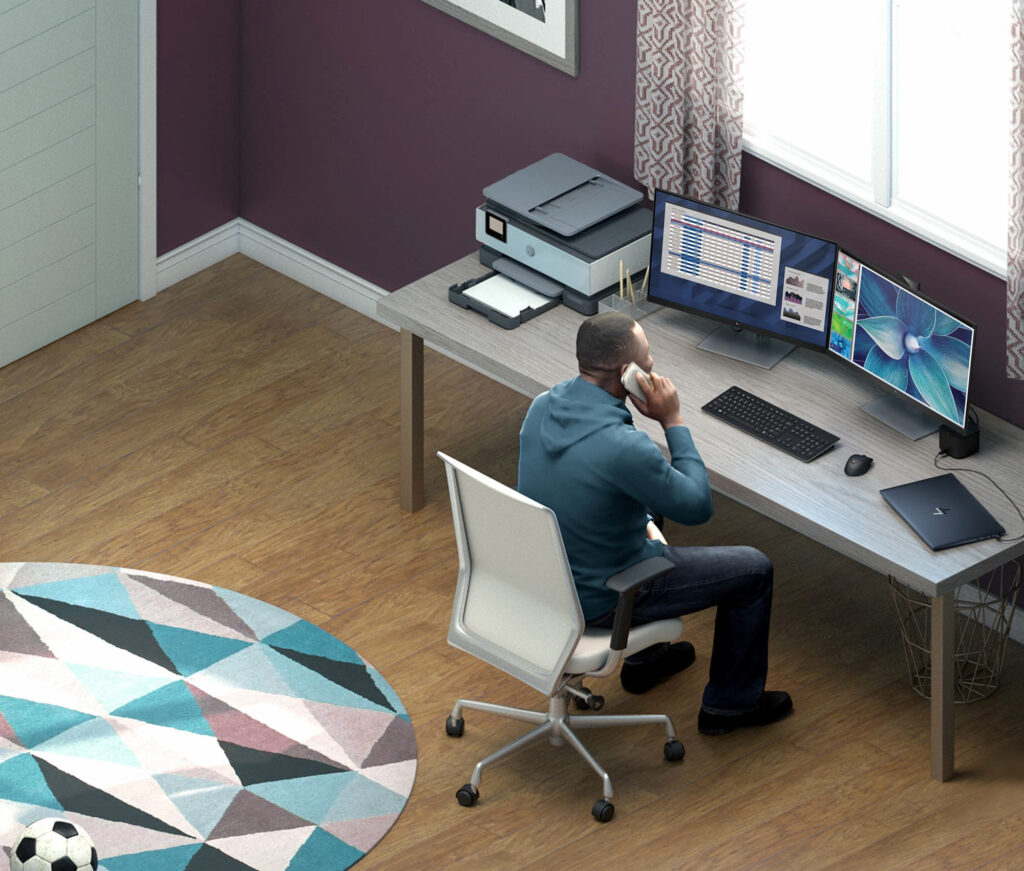 man in home office large windows wood desk dual monitor HP