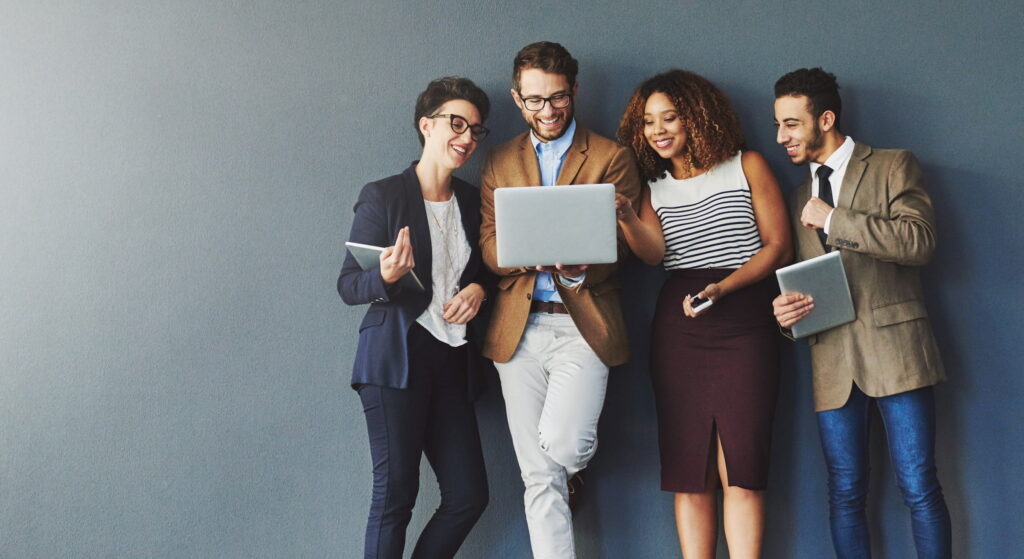 trendy young employees against grey background laptop