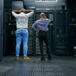 two male stressed it technicians in server room