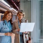 NHS-Mitarbeiter: zwei Frauen – eine Krankenschwester und eine Geschäftsfrau mit Laptop